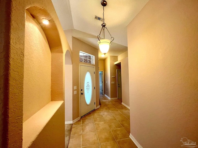 tiled entryway featuring lofted ceiling