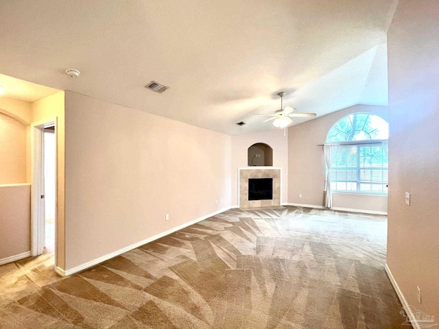 unfurnished living room with carpet flooring, a tile fireplace, ceiling fan, and vaulted ceiling