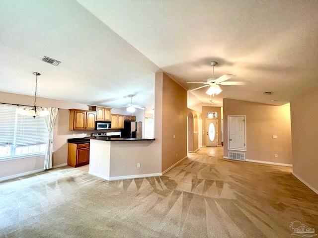 unfurnished living room featuring light carpet, ceiling fan with notable chandelier, and lofted ceiling