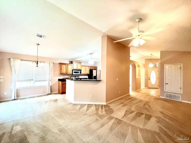 kitchen featuring appliances with stainless steel finishes, lofted ceiling, light colored carpet, and ceiling fan