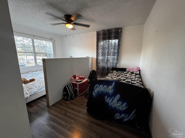 bedroom with ceiling fan, dark hardwood / wood-style flooring, and a textured ceiling