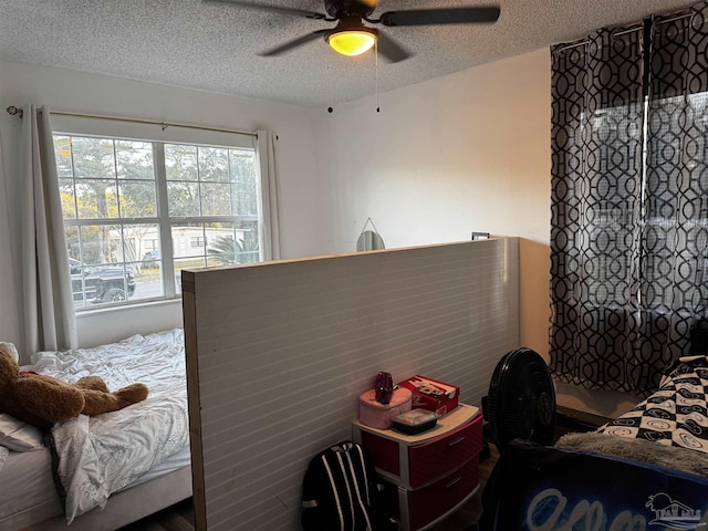 bedroom with ceiling fan and a textured ceiling