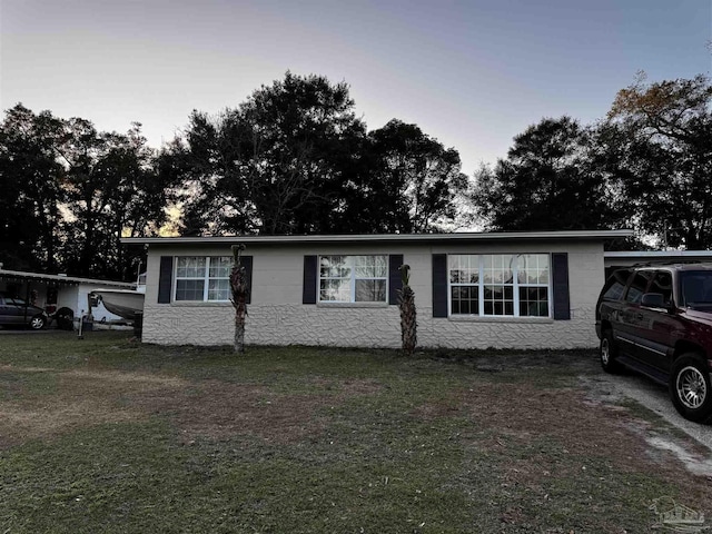 ranch-style home with a yard