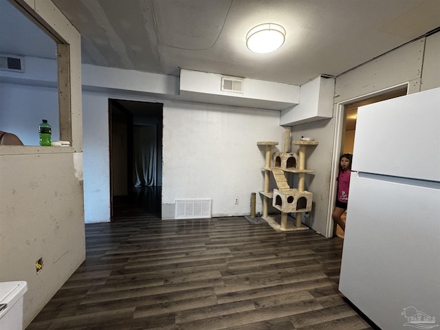 kitchen featuring white cabinets, white refrigerator, and dark wood-type flooring