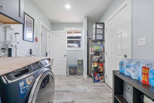 washroom with cabinets and washer / clothes dryer