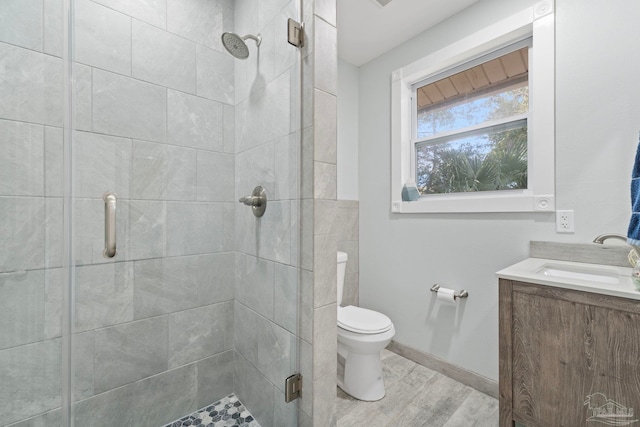 bathroom featuring walk in shower, vanity, toilet, and hardwood / wood-style floors