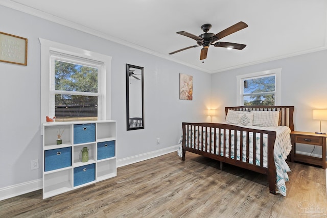 bedroom with crown molding, hardwood / wood-style floors, and multiple windows