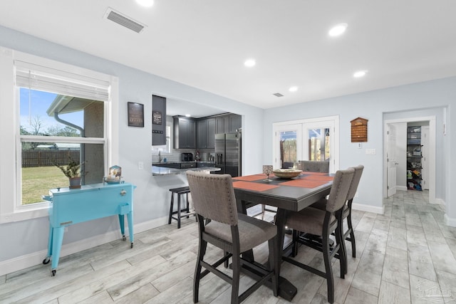 dining room with sink and light hardwood / wood-style flooring