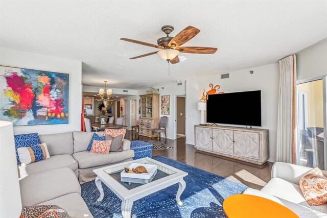 living area featuring ceiling fan with notable chandelier, wood finished floors, and visible vents