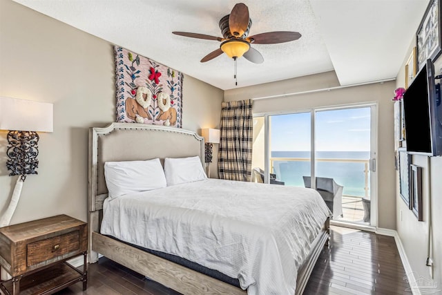 bedroom featuring a textured ceiling, access to exterior, a ceiling fan, baseboards, and wood finished floors