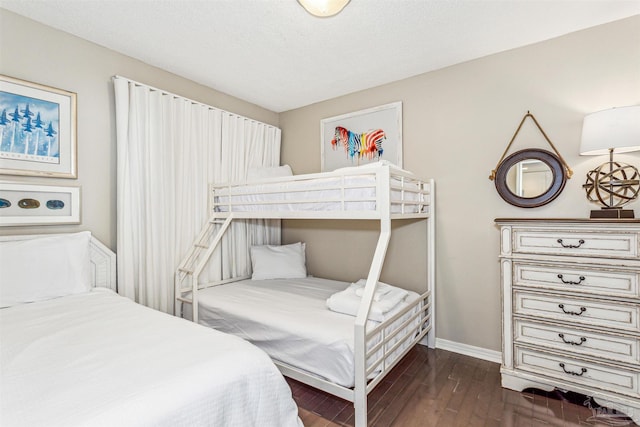 bedroom with baseboards and dark wood-style floors