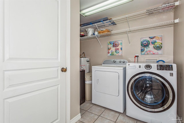 washroom featuring laundry area, washer and clothes dryer, and light tile patterned floors