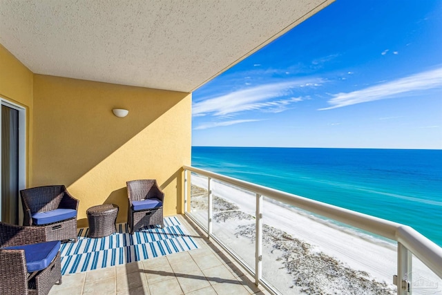 balcony with a water view and a beach view