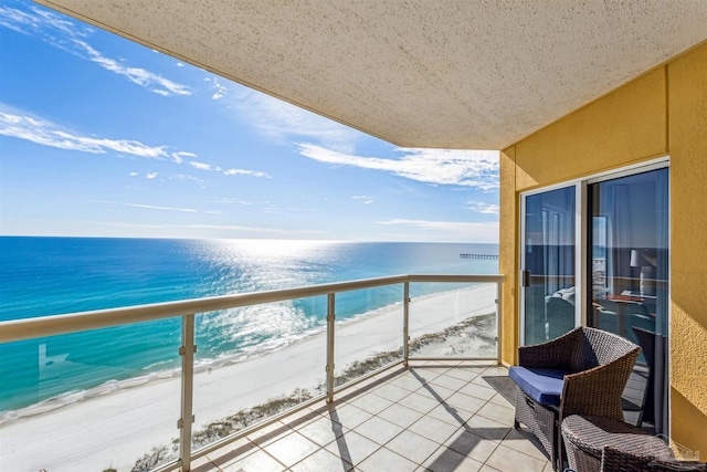 balcony with a water view and a view of the beach