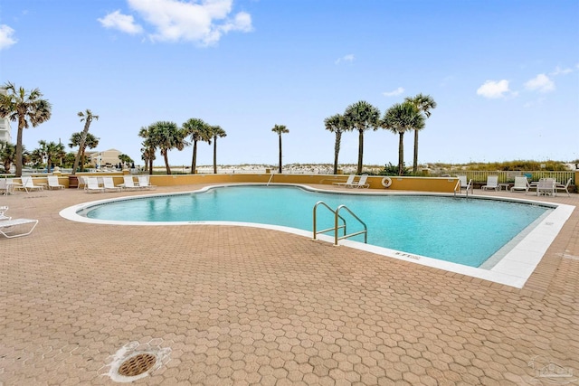 pool featuring fence and a patio area