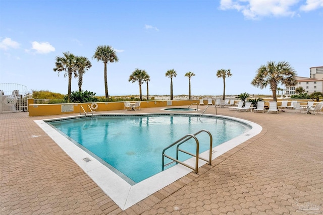 community pool with a community hot tub and a patio area