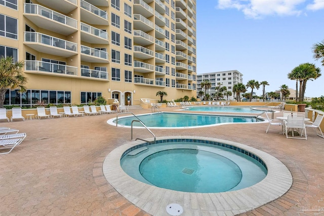 community pool featuring a patio and a community hot tub
