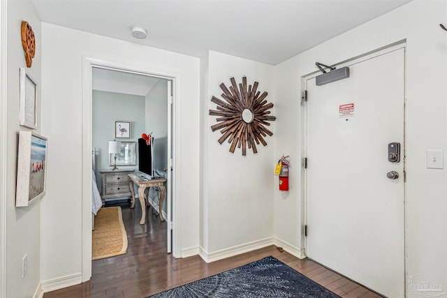 entryway featuring baseboards and dark wood-style floors