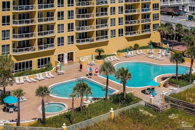 community pool with a patio and a hot tub