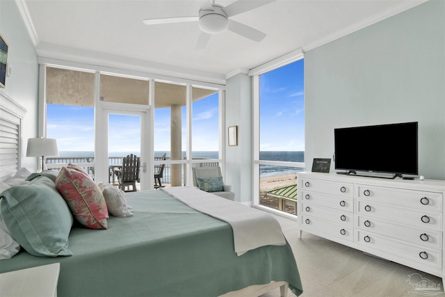 bedroom featuring expansive windows, ceiling fan, crown molding, a water view, and light carpet