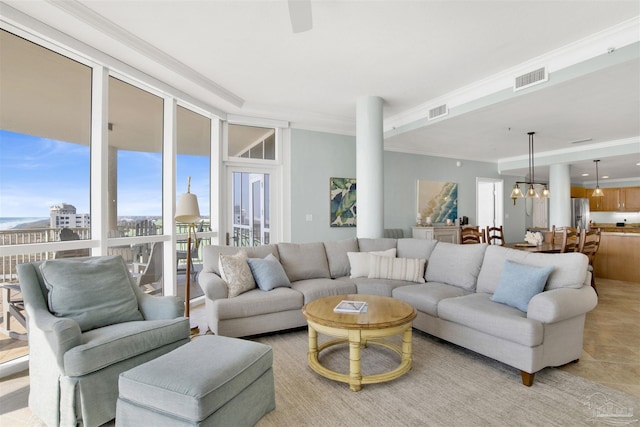 living room featuring crown molding, light tile patterned floors, and a notable chandelier