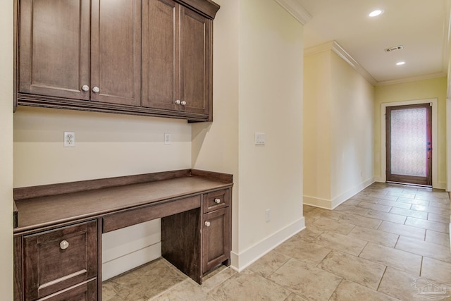 unfurnished office featuring built in desk and crown molding