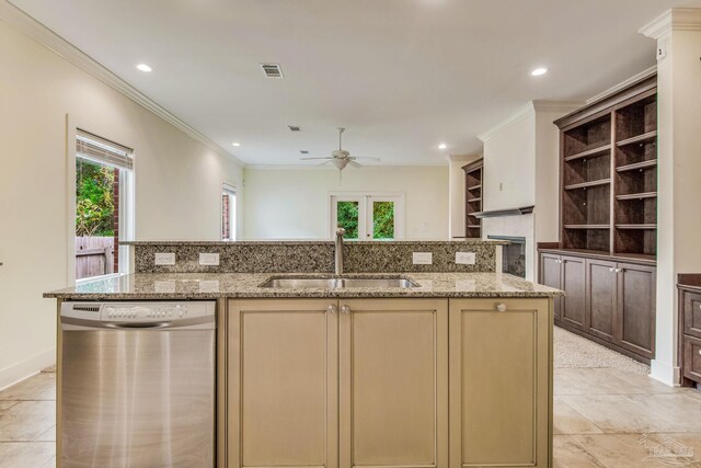 kitchen featuring light stone counters, sink, stainless steel dishwasher, and plenty of natural light