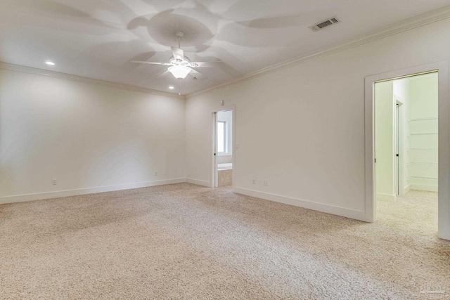 empty room featuring carpet, ceiling fan, and crown molding