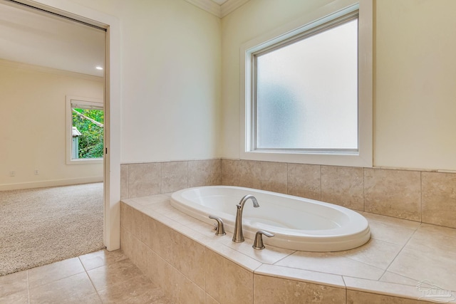 bathroom with ornamental molding and tiled tub