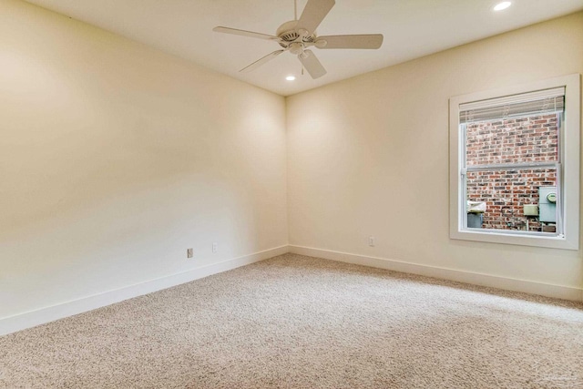 carpeted spare room featuring ceiling fan