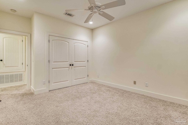 unfurnished bedroom with ceiling fan, light carpet, and a closet