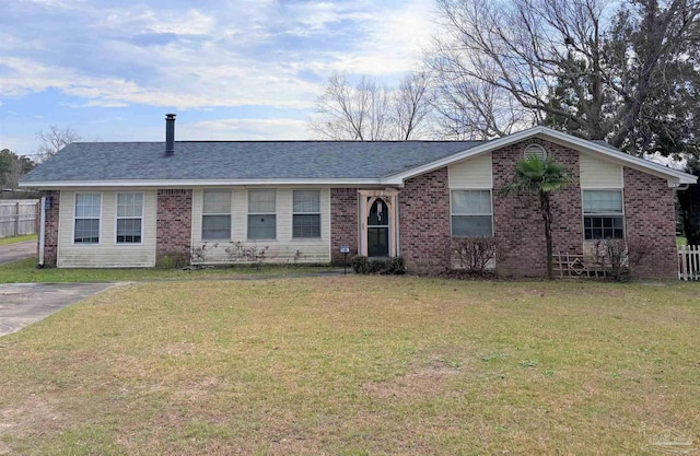 single story home featuring brick siding, a front lawn, and roof with shingles