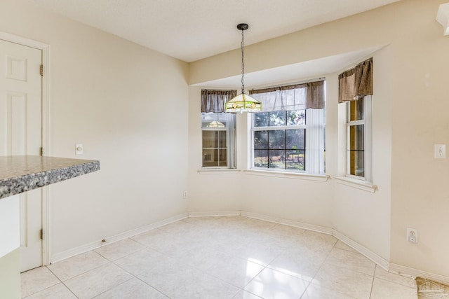 unfurnished dining area featuring light tile patterned flooring