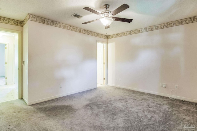 carpeted empty room with a textured ceiling and ceiling fan