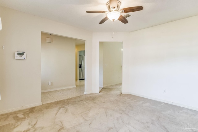 unfurnished room featuring ceiling fan and light carpet