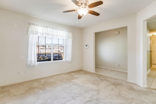 carpeted spare room featuring ceiling fan