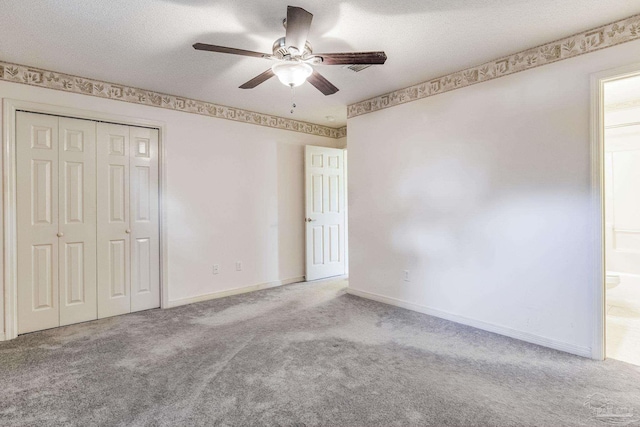 unfurnished bedroom with connected bathroom, ceiling fan, a textured ceiling, light carpet, and a closet