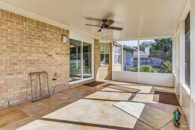 unfurnished sunroom with ceiling fan