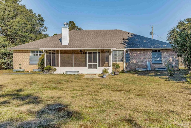 rear view of property featuring a sunroom and a yard