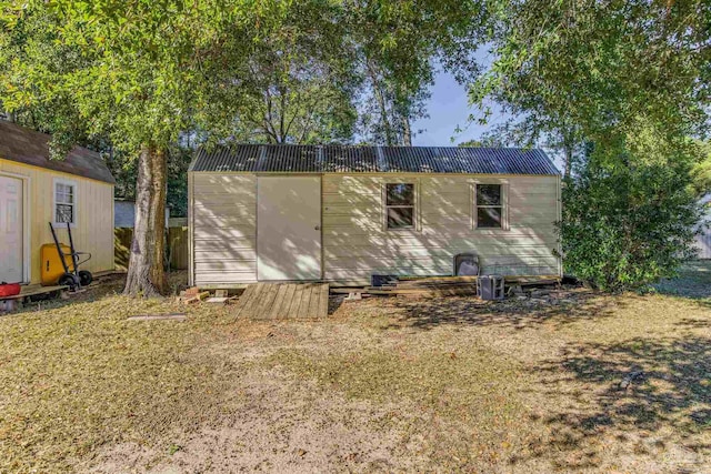 rear view of property featuring a storage unit