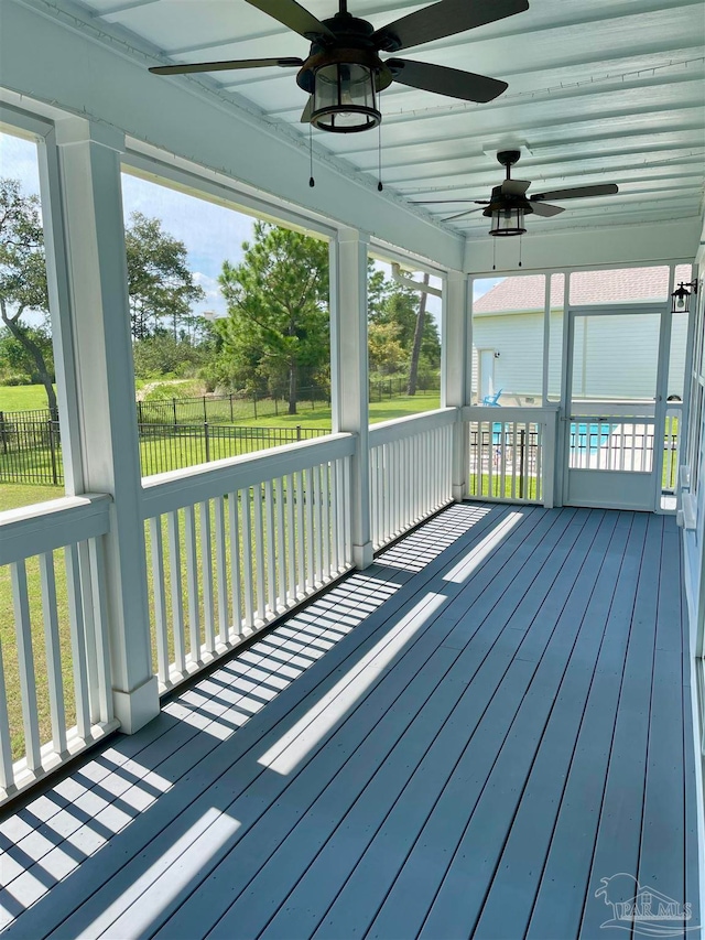 unfurnished sunroom with ceiling fan