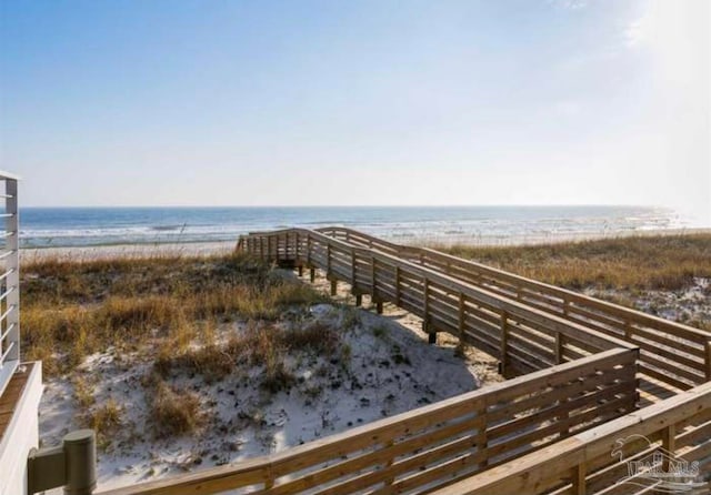 view of property's community featuring a water view and a beach view