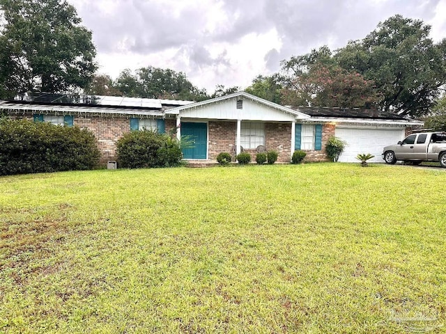 single story home featuring a garage, a front lawn, and solar panels