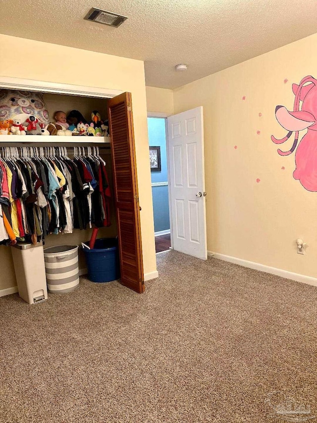 unfurnished bedroom with carpet floors, a closet, and a textured ceiling