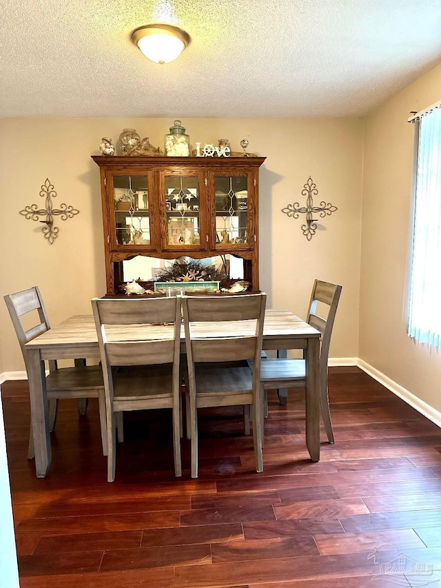 dining room featuring dark hardwood / wood-style floors and a textured ceiling