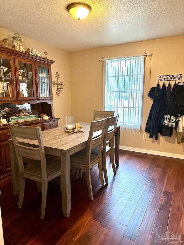 dining area with dark hardwood / wood-style floors and a textured ceiling