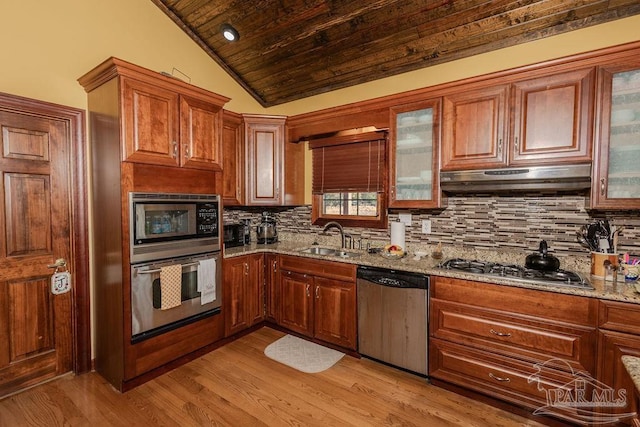 kitchen with light stone countertops, tasteful backsplash, stainless steel appliances, sink, and lofted ceiling