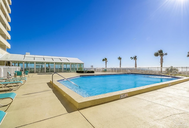 community pool featuring fence and a patio