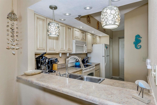 kitchen with white appliances, cream cabinets, decorative light fixtures, light countertops, and a sink