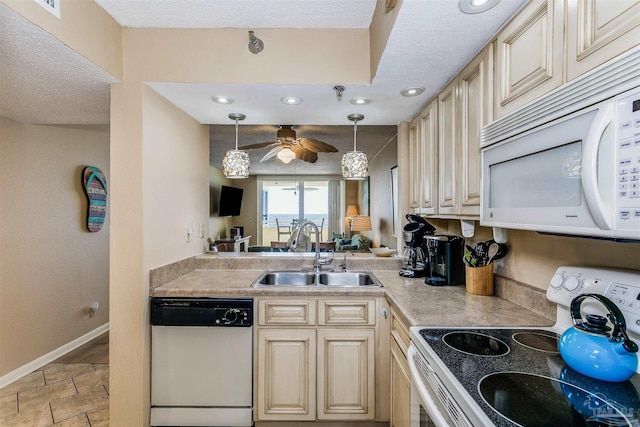 kitchen with a sink, cream cabinets, a ceiling fan, white appliances, and hanging light fixtures